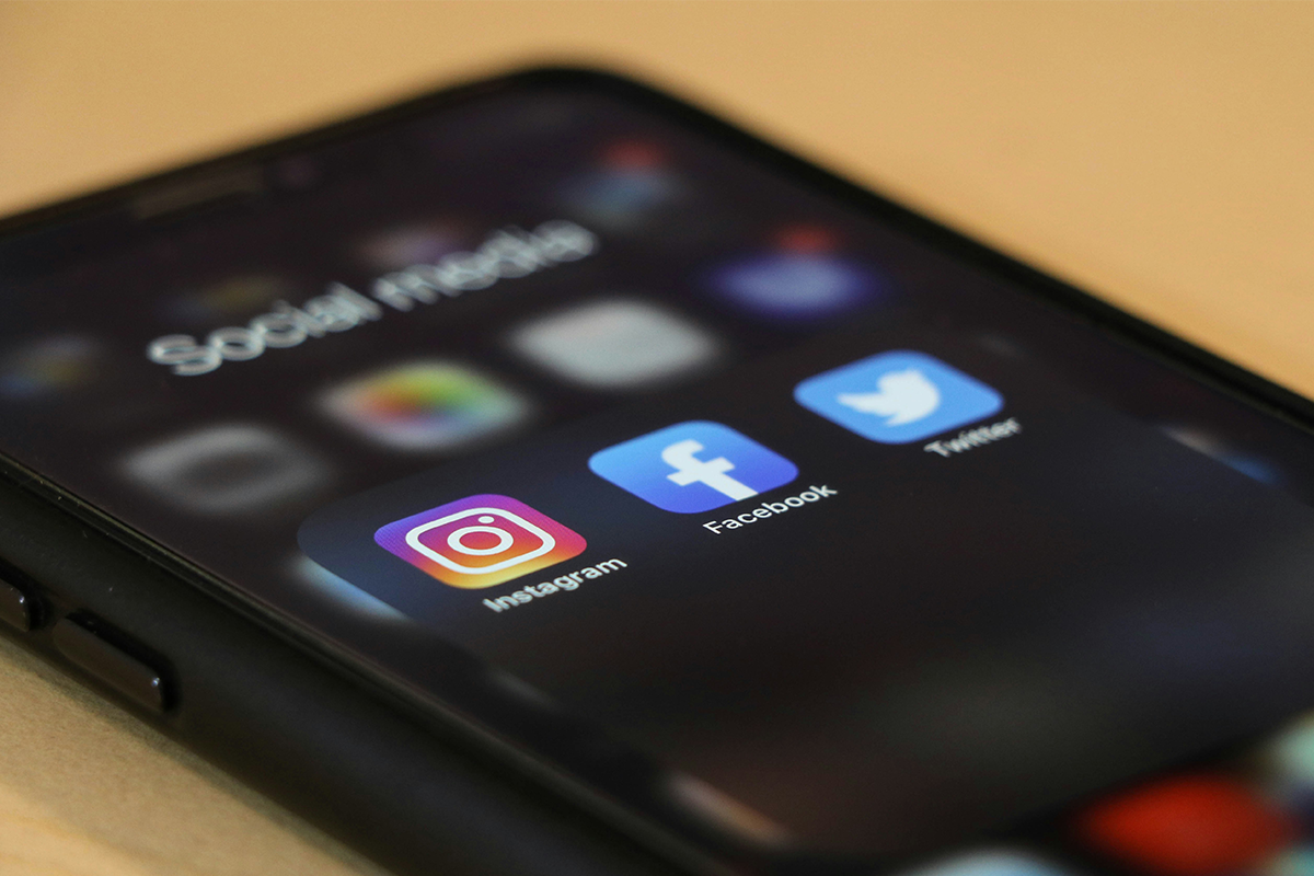 Celular exibindo redes sociais como Instagram, Facebook e Twitter representando estratégias de posicionamento digital